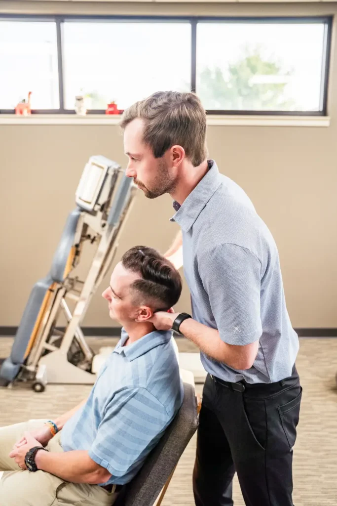 Dr. Britton Goldsmith performing a neck adjustment on a male patient