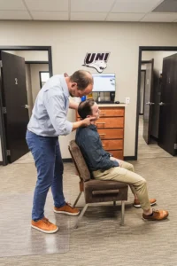 Dr. Blake Wayson adjusting a male patient's neck