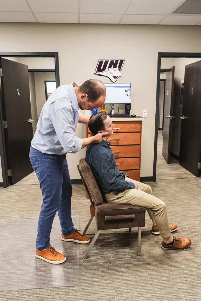 Dr. Blake Wayson adjusting a male patient's neck
