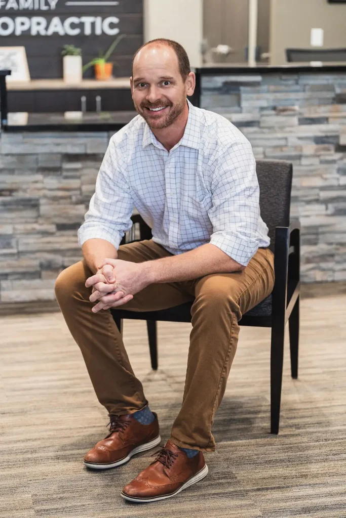 Dr. Blake Wayson of Wayson Family Chiropractic smiling at camera for a professional photo sitting in a chair