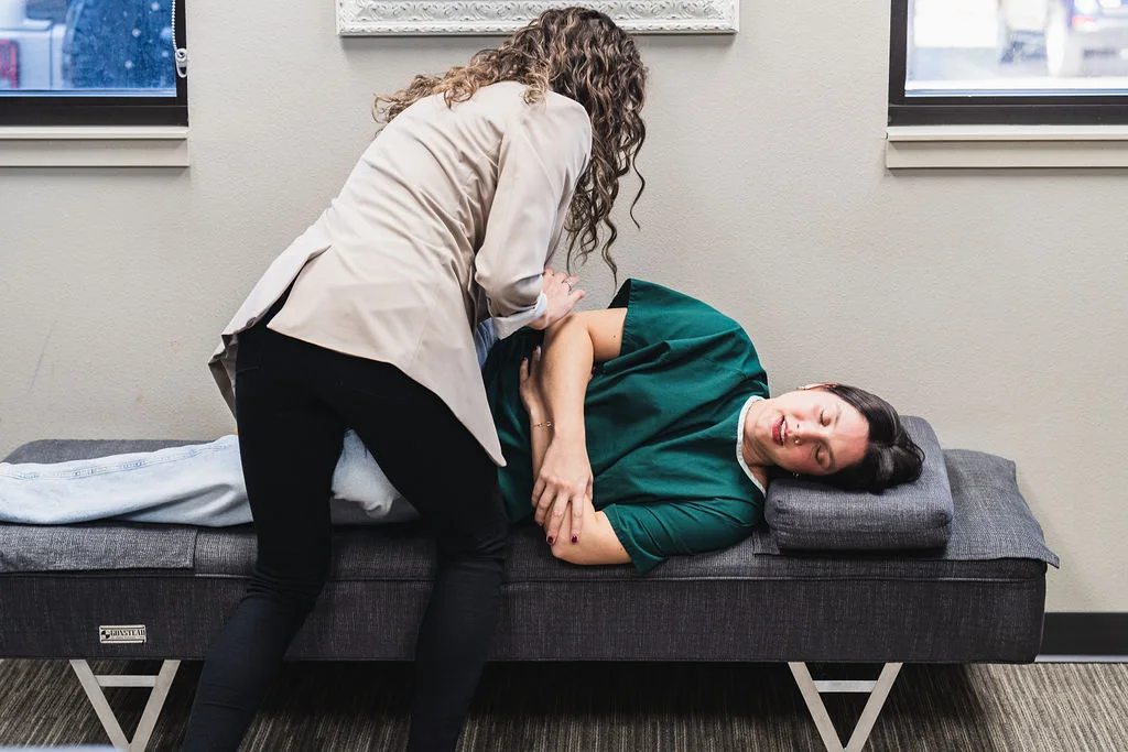 Dr. Sara Cahill performing a spinal adjustment for female patient
