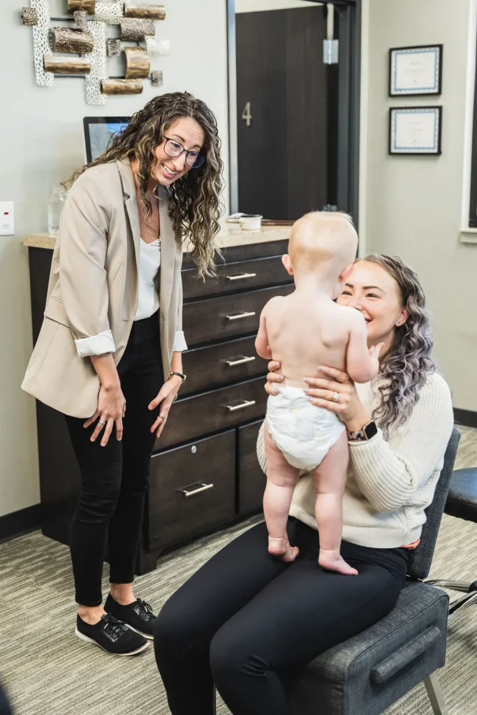 Dr. Sara Cahill meeting a baby with her mother smiling