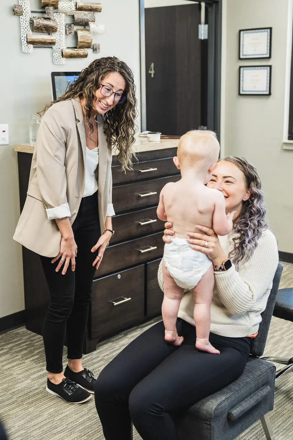 Dr. Sara Cahill meeting a baby with her mother smiling