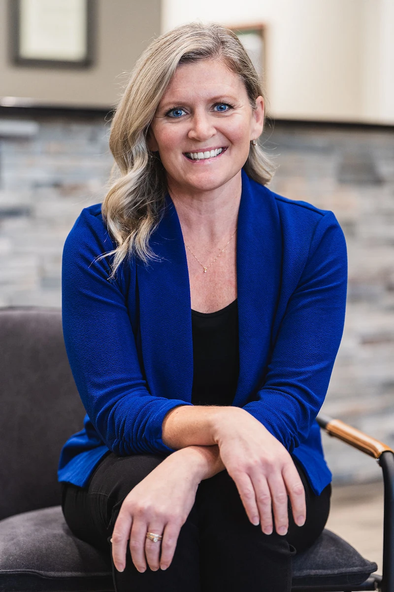 Wayson Family Chiropractic staff Jen smiling looking professional sitting on chair
