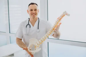 Chiropractor explaining spine model to male patient