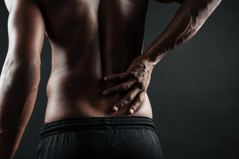 Man clutching back due to acute spinal pain