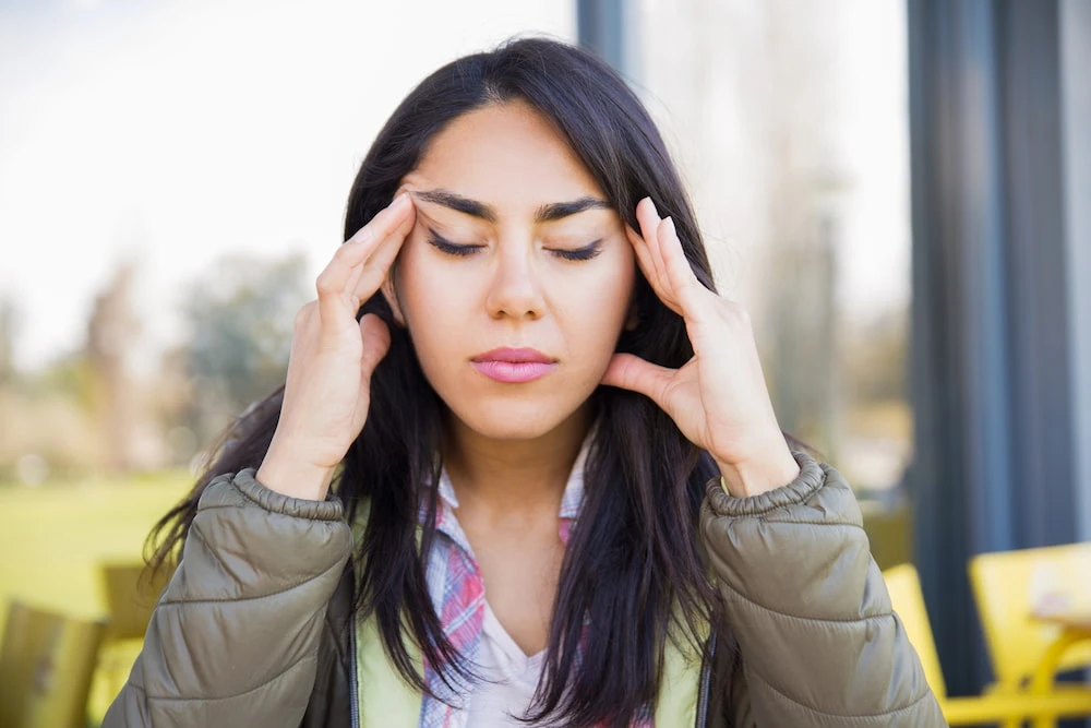 Fatigued woman experiencing persistent headache pain