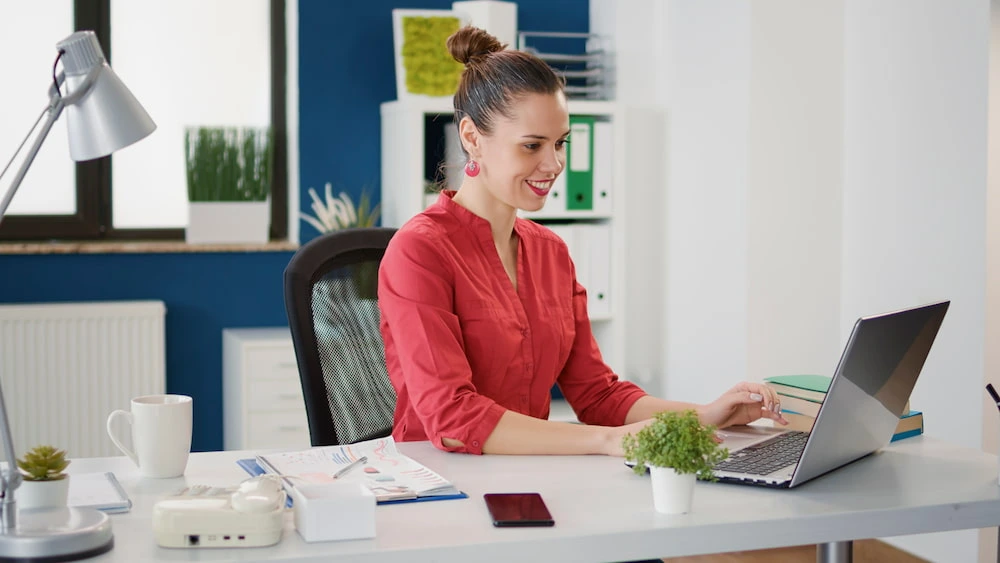Woman working on laptop with poor desk posture