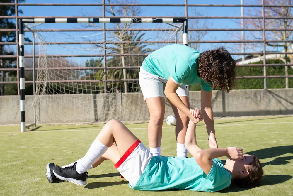 Young football player on ground with sports injury