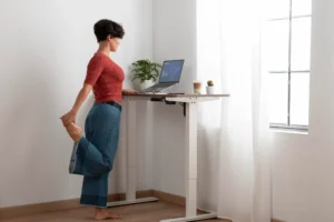 Office worker adjusting posture while using standing desk