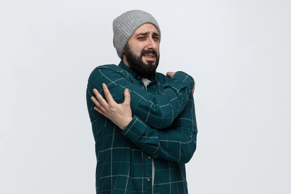 Man holding shoulder due to joint pain in cold weather